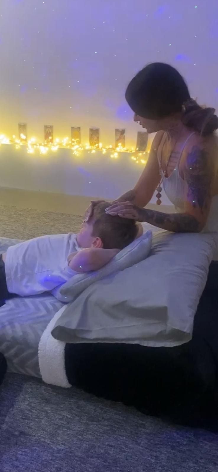 Kate providing hands-on Reiki healing with ambient lighting